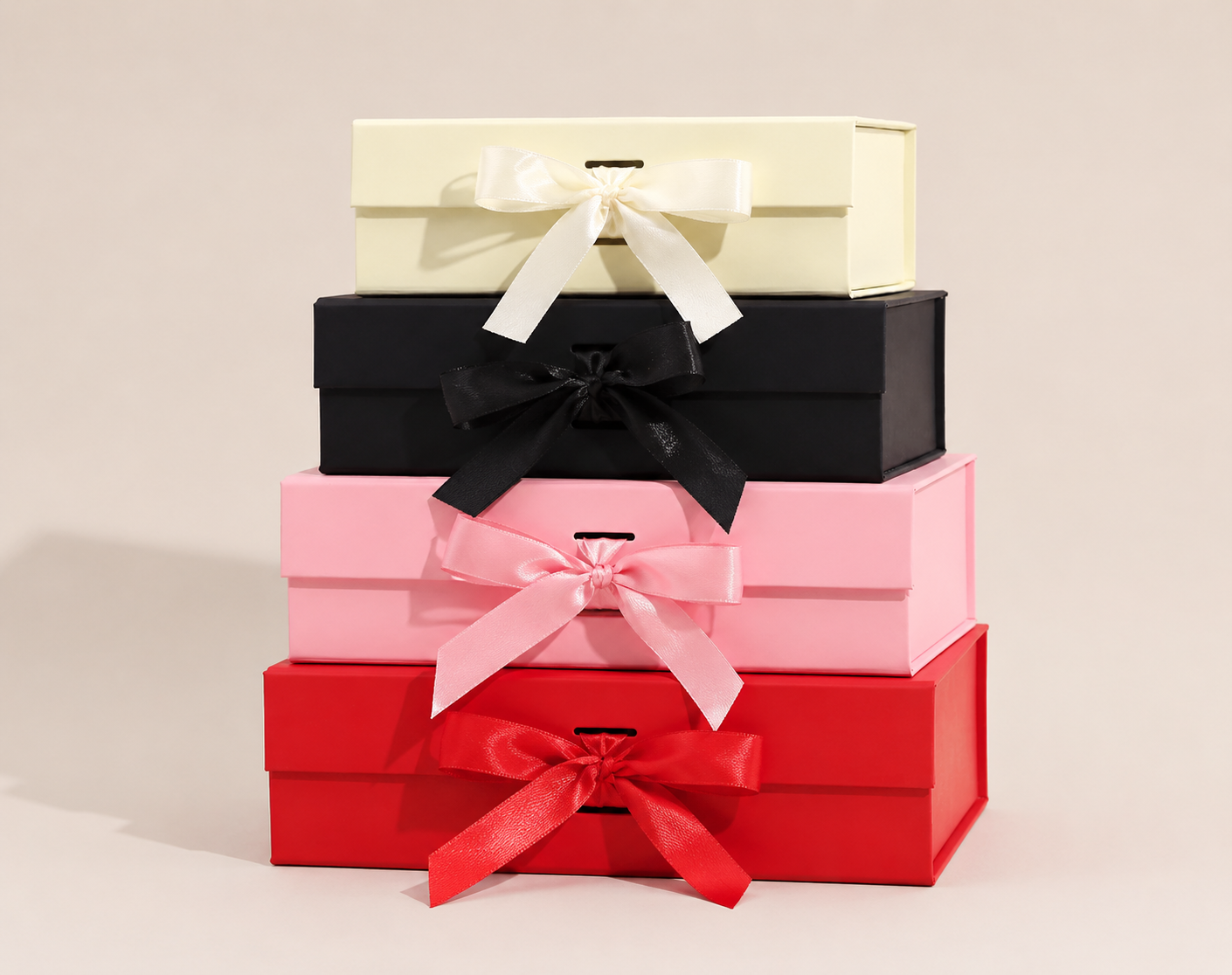 Stack of cream, black, pink and red ribbon gift boxes