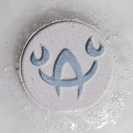 Circular object with a blue symbol on a textured gray background