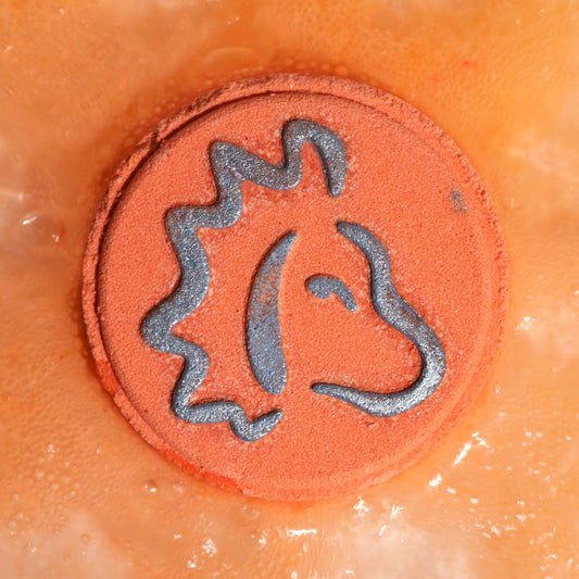 Close-up of a circular object with a horse logo on an orange background