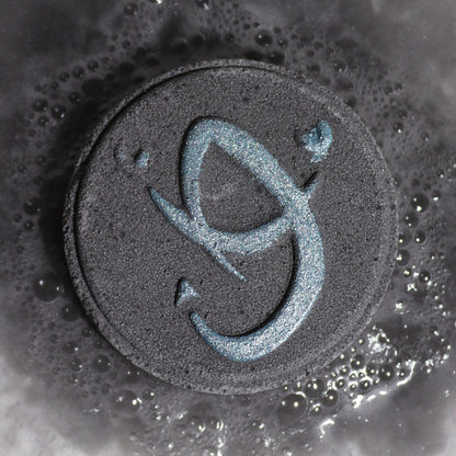 Black circular object with a blue symbol on a textured surface