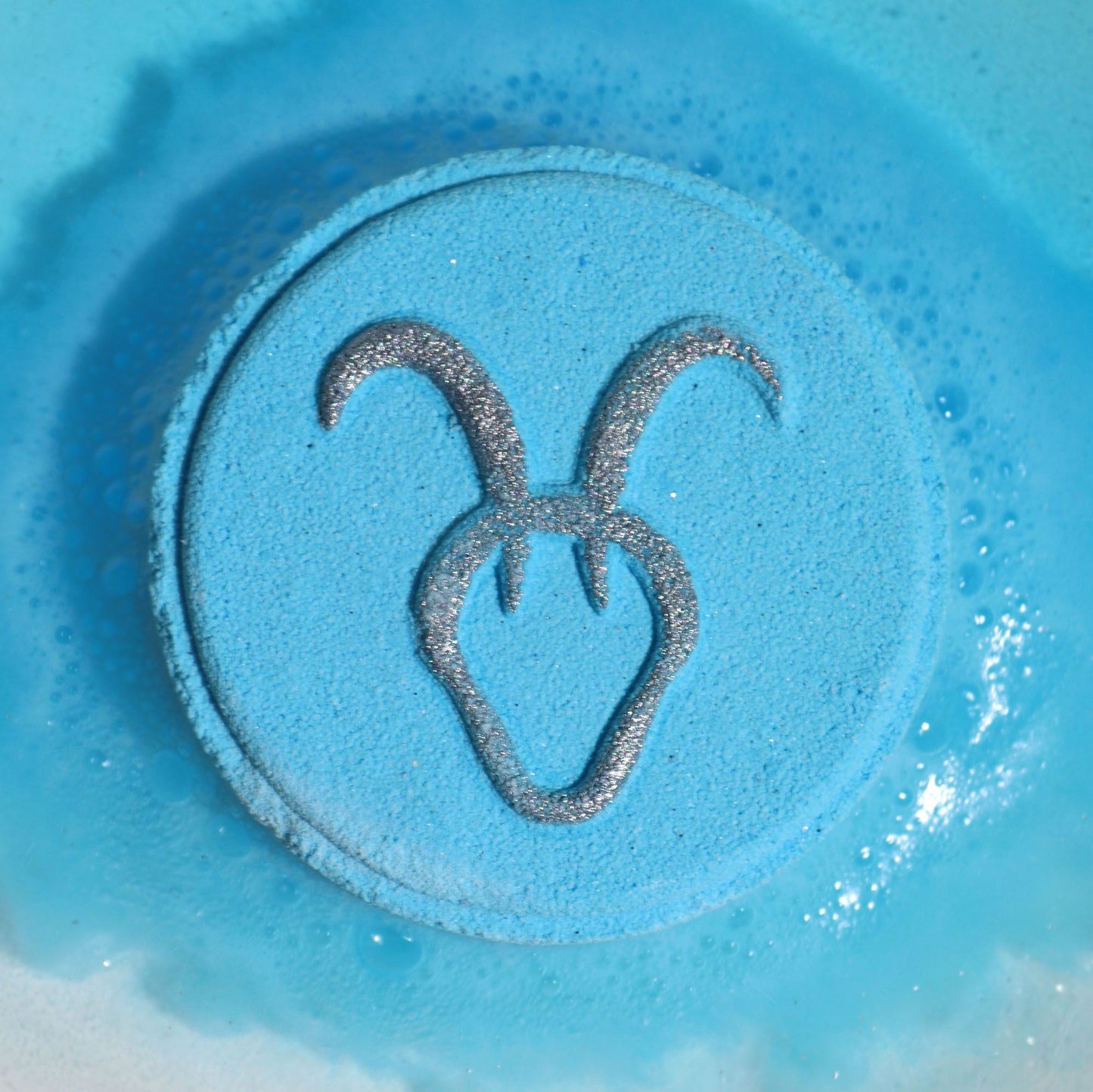 Blue sand with a symbol resembling a strawberry on a blue background